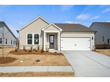 Charming single-story home showcasing a light exterior, manicured lawn, and an attached two-car garage at 1783 Juniper Berry Way, Loganville, GA 30052