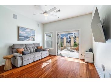 Bright living room featuring hardwood floors and glass doors to private patio at 870 Inman Village Ne Pkwy # 229, Atlanta, GA 30307