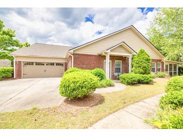 Charming brick home with a two-car garage and a well-manicured lawn, perfect for curb appeal at 2318 Chancery Mill Ln, Buford, GA 30519