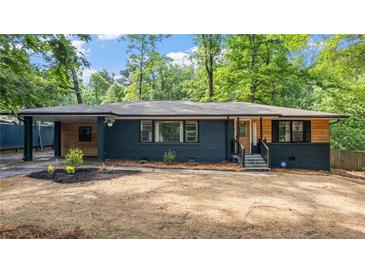 Charming one-story home featuring a brick facade, wood accents, a covered carport, and manicured landscaping at 715 Wood Valley Rd, Mableton, GA 30126