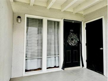 Charming entryway with a black front door and decorative wreath, adjacent to bright windows at 1150 Collier Nw Rd # 25D, Atlanta, GA 30318