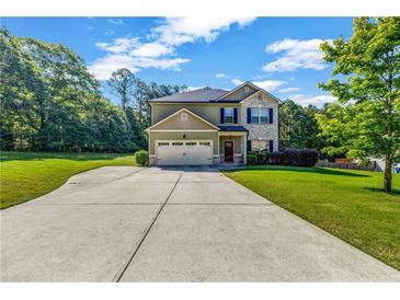 Charming home featuring a well-maintained lawn, long driveway, and attached garage at 2102 Braswell Ln, Loganville, GA 30052