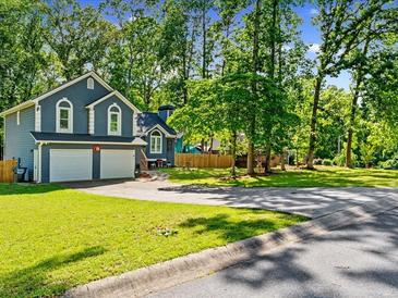 Charming two-story home featuring a two-car garage, well-maintained lawn, and mature trees providing ample shade at 2723 Horseshoe Creek Sw Dr, Marietta, GA 30064