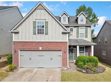Charming two-story home featuring a brick facade, well-maintained lawn, and attached two-car garage at 121 Camdyn Cir, Woodstock, GA 30188
