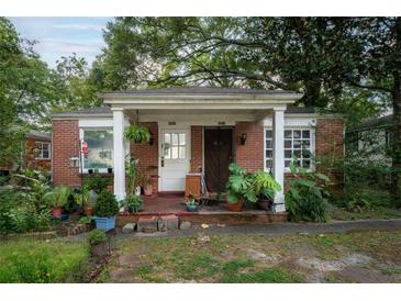 Charming brick home with a cozy front porch and abundant greenery at 1336 Sharon St, Atlanta, GA 30314
