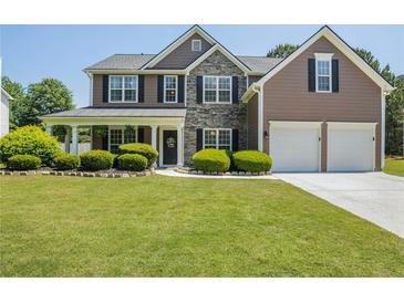 Charming two-story home featuring manicured lawn, stone accents, and a welcoming covered front porch at 868 Cork Oak Ln, Lawrenceville, GA 30045