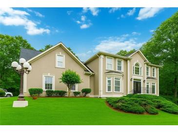 Charming two-story home featuring a well-manicured lawn, beautiful landscaping, and a classic architectural style at 4002 Turnstone Nw Dr, Kennesaw, GA 30152