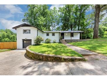 Charming white brick home with lush green lawn and driveway at 3807 Greenhill Dr, Chamblee, GA 30341