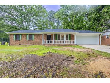 Charming brick ranch home featuring a front porch and well-manicured landscaping at 5964 W Fayetteville Rd, Atlanta, GA 30349