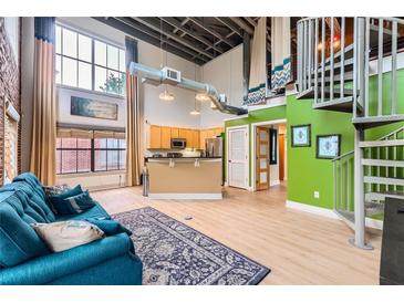 Bright and airy living room featuring a modern kitchen, spiral staircase, and large windows with natural light at 791 Wylie Se St # 410, Atlanta, GA 30316