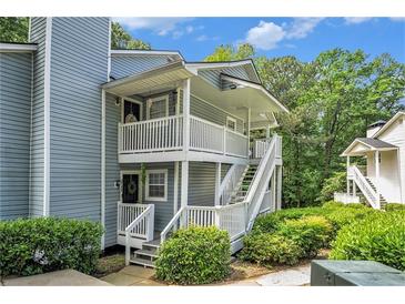 Inviting two-story condo with dual balconies, surrounded by lush greenery and freshly landscaped yard at 2748 Suwanee Se Way, Marietta, GA 30067