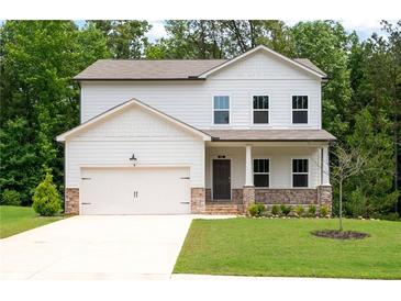 Charming two-story home with a well-manicured lawn and a welcoming front porch and attached two car garage at 63 Brookstone E Park, Acworth, GA 30101