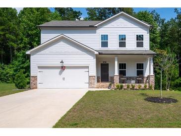 Charming two-story home featuring stone accents, a covered porch, and an attached two-car garage at 63 Brookstone E Park, Acworth, GA 30101