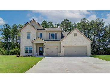 Two-story home with brick accents, a spacious driveway, and an attached two-car garage at 211 Linford Dr, Locust Grove, GA 30248