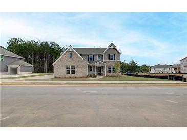 Beautiful new construction home featuring a mix of brick and siding and a manicured lawn at 234 Linford Dr, Locust Grove, GA 30248