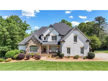 Stunning two-story home with a stone facade, lush landscaping, and a welcoming front porch at 104 Meadow View Trl, Canton, GA 30115