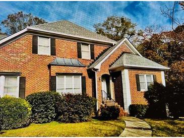 Charming brick home featuring a manicured lawn, black window shutters, and a welcoming entrance at 1019 Henna Se Ct, Conyers, GA 30013