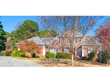 Charming two-story brick home featuring manicured landscaping and a well-maintained lawn on a sunny day at 1019 Henna Se Ct, Conyers, GA 30013