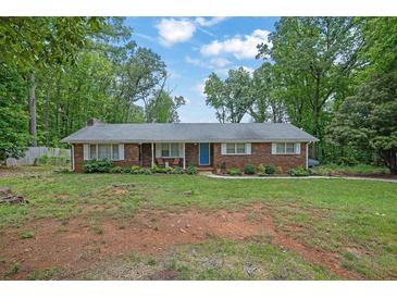 Charming brick home featuring a well-maintained front yard with mature trees and a cozy front porch at 1192 Pathfinder Rd, Marietta, GA 30066
