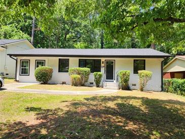 Charming single-story home boasts a freshly painted white exterior, black-trimmed windows, and a well-maintained front yard at 188 Oak Dr, Atlanta, GA 30354