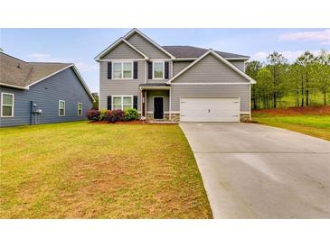 Charming two-story home featuring a gray exterior, manicured lawn, and a concrete driveway leading to a two-car garage at 209 Shelton Cir, Temple, GA 30179