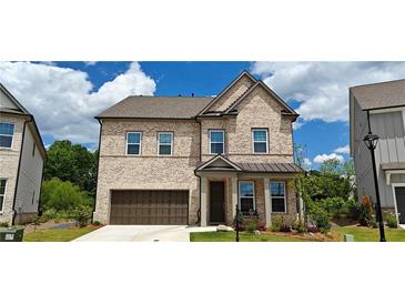 Two-story brick home with a covered front porch and a two-car garage, surrounded by a well-manicured lawn at 2962 Girard Ln, Duluth, GA 30097