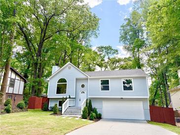 Charming two-story home with a manicured lawn, a garage, and beautiful landscaping at 8399 Lake Dr, Snellville, GA 30039