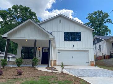 Charming two-story home featuring white siding, a covered front porch, and a paved driveway at 2167 Main Nw St, Atlanta, GA 30318