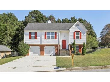 Charming two-story home featuring a two-car garage, red shutters and door, and a well-manicured front yard at 915 Terance Ave, Jonesboro, GA 30238