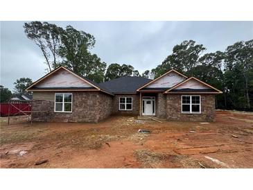 Charming single-story home with a stone facade, dark roof, and large windows at 5351 Tuscany Dr, Douglasville, GA 30135