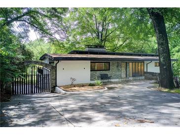 Charming single story home featuring gated entrance, modern design elements, and a beautifully landscaped front yard at 1676 Moores Mill Nw Rd, Atlanta, GA 30327