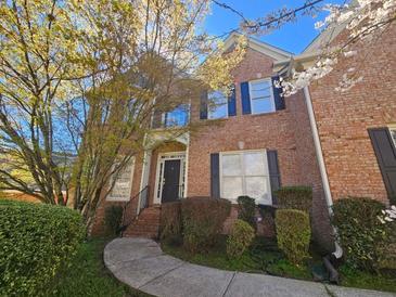 Charming brick two-story home with black shutters, landscaped yard, and stone walkway at 4091 Oberon Se Ct, Smyrna, GA 30080