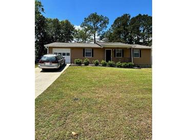 Charming single-story home featuring a well-manicured lawn and a classic facade with a garage on the side at 1736 Almand Creek Sw Dr, Conyers, GA 30094