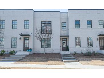 Modern townhome exterior featuring a light brick facade and well-manicured front yards at 3611 Ridgeway Rd, Duluth, GA 30096
