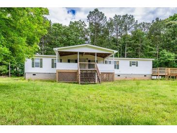 Charming single-story home features a large front porch, wooden deck, and a spacious lawn with mature trees at 743 New Hope Rd, Lawrenceville, GA 30046