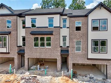 Newly constructed brick townhomes featuring open garage space and large window views at 4 Rock Park Way # 14, Tucker, GA 30084