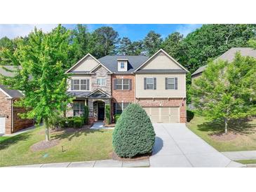 Inviting two-story home featuring a well-manicured lawn and a blend of brick, stone, and siding accents at 4610 Point Rock Dr, Buford, GA 30519