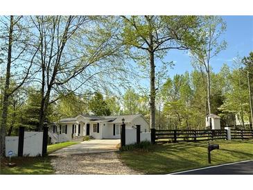 Charming home featuring a well-manicured lawn, white exterior, and a fenced yard at 3014 Echols Rd, Cumming, GA 30041