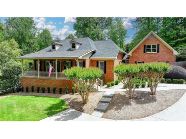 Charming brick home featuring a welcoming front porch and well-manicured landscaping at 5335 Bannergate Dr, Johns Creek, GA 30022