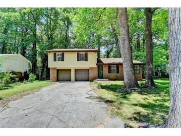 Charming two-story home with brick and siding, a two-car garage, and surrounded by mature trees at 6419 Danbury Ln, Norcross, GA 30093