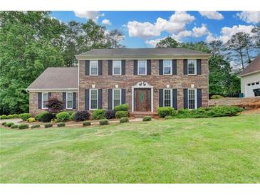 Charming two-story brick home with a manicured lawn and mature landscaping creates a welcoming curb appeal at 478 Guilford Cir, Marietta, GA 30068