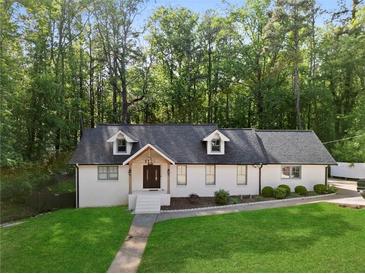 Charming ranch-style home with a well-manicured lawn and a classic brick exterior with a wooded backdrop at 1125 Murray Sw Cir, Marietta, GA 30064