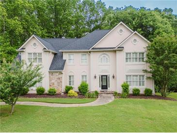 Charming two-story home featuring a manicured lawn, stone accents, and mature trees adding to its curb appeal at 2552 Berwick Walk, Snellville, GA 30078