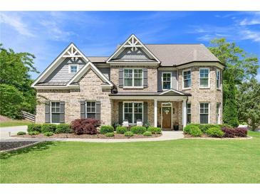 Charming two-story brick home with manicured landscaping and a welcoming front porch at 592 Hayes Rd, Auburn, GA 30011
