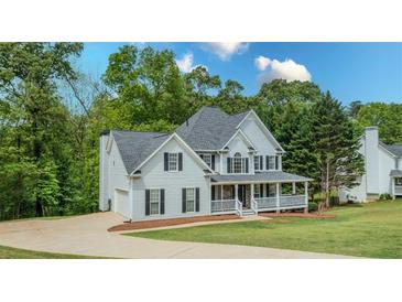 Charming two-story home featuring a welcoming front porch and lush landscaping at 102 Woodsfield Ln, Hiram, GA 30141