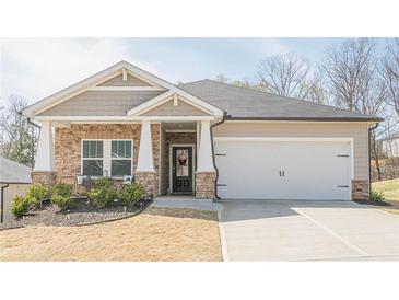 Charming one-story home with a stone facade, covered porch, and well-manicured front yard and a two car garage at 422 Murphy Avenue, Canton, GA 30114