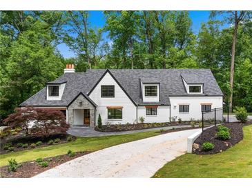 Stunning home with manicured lawn, long driveway, and striking architecture with modern, dark-trimmed windows at 1155 Peachtree Battle Nw Ave, Atlanta, GA 30327