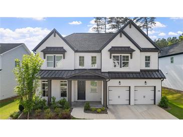 Beautiful two-story home featuring white brick, a dark gray roof, and a two-car garage at 298 Tillman Pass, Woodstock, GA 30188