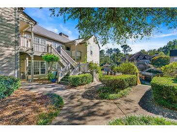 Inviting two-story condo with lush landscaping and walkway leading to the entrance, perfect for peaceful living at 610 Mill Pond Se Dr, Smyrna, GA 30082