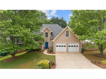 Charming two-story home featuring a well-manicured lawn, attached two-car garage, and a welcoming blue front door at 865 Ashfield Dr, Decatur, GA 30030